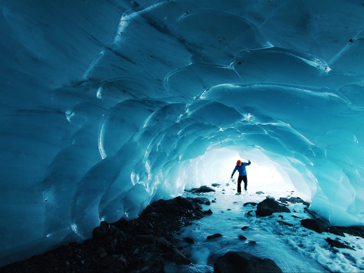 Homme dans une grotte glaciaire bleue